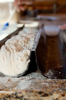 A baker prepares handmade artisan bread for baking.
