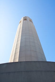 A view of Coit Tower in downtown San Francisco photographed from below looking up.