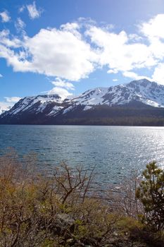 Views of Lake Tahoe in California with crystal clear water, snow on the ground, and mountains in the background.