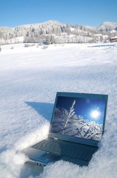 Laptop in a winter landscape scene outdoors