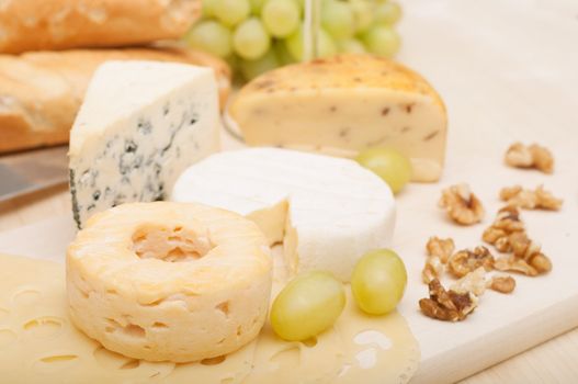 Various Types of Cheese and Grapes on Wooden Chopping Board