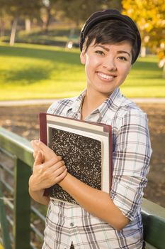 Outdoor Portrait of a Pretty Mixed Race Female Student Holding Books on a Sunny Afternoon.