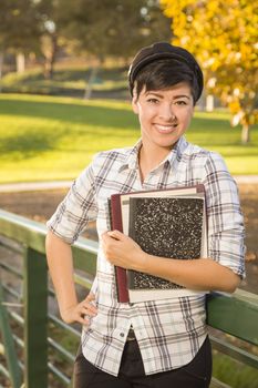 Outdoor Portrait of a Pretty Mixed Race Female Student Holding Books on a Sunny Afternoon.