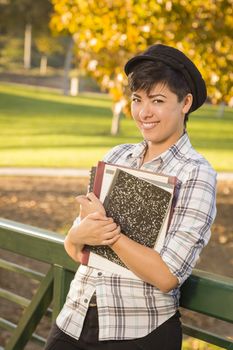 Outdoor Portrait of a Pretty Mixed Race Female Student Holding Books on a Sunny Afternoon.