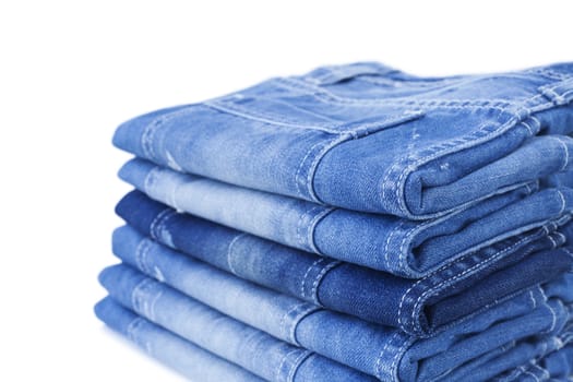 Stack of blue jeans isolated on white background