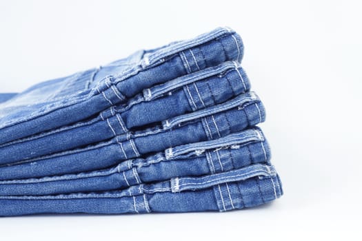 Stack of blue jeans isolated on white background