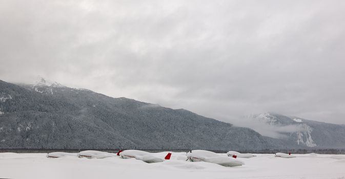 The snow-covered airport with the planes filled up with snow. Alaska.