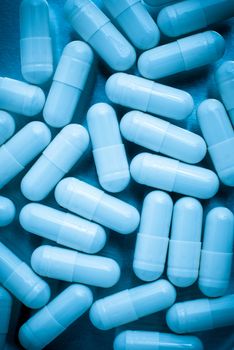 Macro view of pills on blue lit.