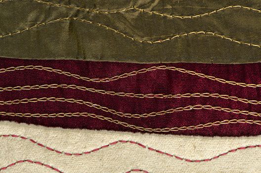 A red cloth texture with strong contrast and lines with golden decorative chains.