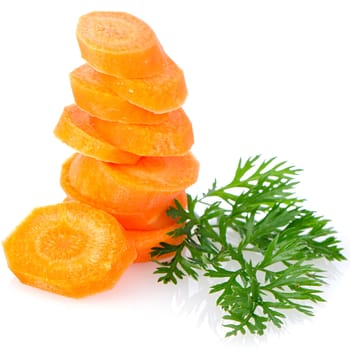 Pile of carrot slices and green parsley leaves closeup on white reflective background.