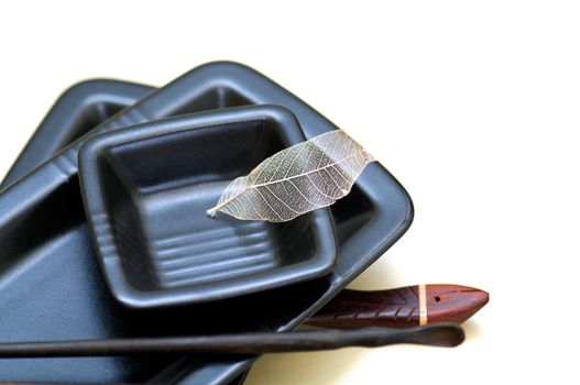 Heap of Blank Black Sushi Plates and Sticks closeup on white background