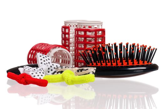 Red hair curlers and hairbrush isolated on white background