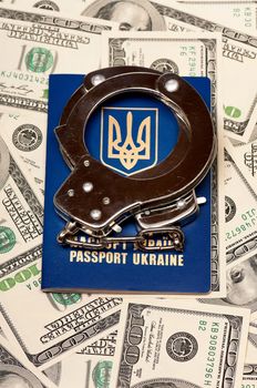 International Ukrainian passport with handcuffs on US dollars background