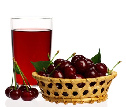 Sweet cherries in a basket and glass of juice on a white background