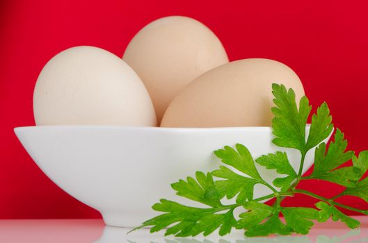 Eggs,Three eggs in the bowl on a red background.