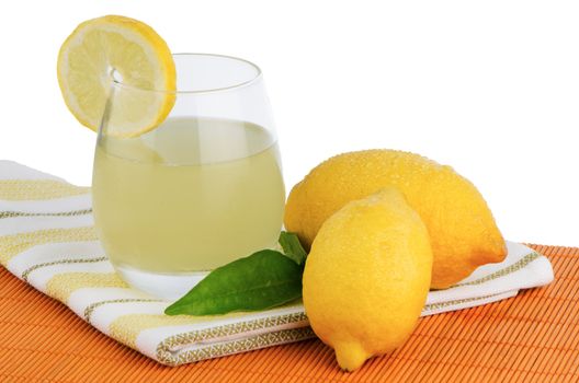 Cup of lemon juice and fresh lemons as a background