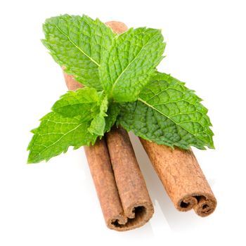 Cinnamon sticks and fresh bergamot mint leaf on white background.