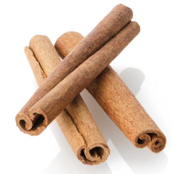 Cinnamon sticks on white reflective background.