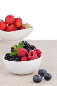 White ceramic bowl of sweet berries fruits.