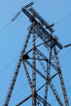 Power lines and electricity pylon  against blue sky