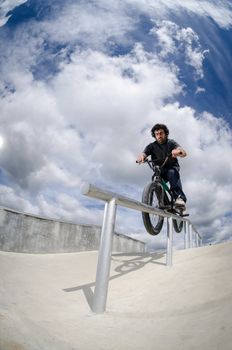 Biker doing double peg grind down the hand rail over the stairs