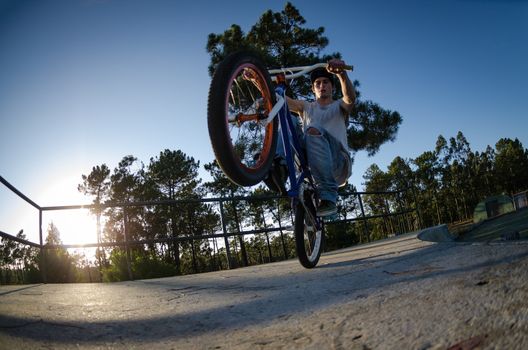 Bmx rider on a ramp over clear sky background.