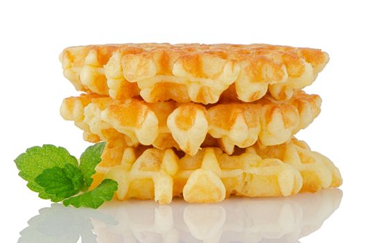 Pile of sweet waffles with green mint leaves isolated on white background.