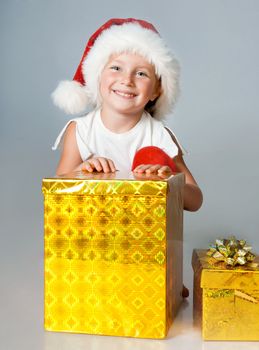 little girl in Santa hat with gifts