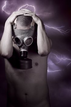 Man in a gas mask looking at floor, storm at background