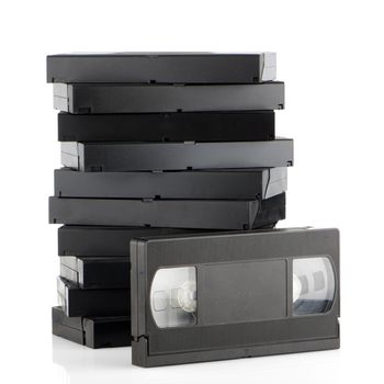 Pile of videotapes on  white reflective background.