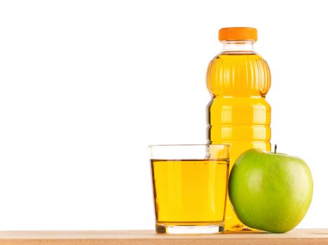 Apple juice in plastic bottle and glass on wooden board over white background
