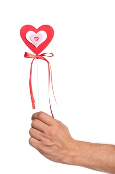 Man hand with heart on a stick with red ribbon isolated on white background