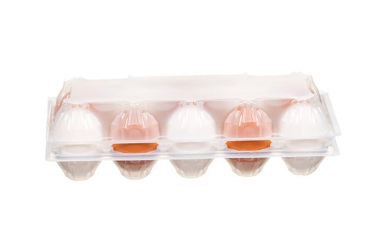 Brown and white eggs in the plastic box over white background