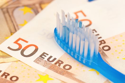 Close-up of tooth brush on heap of euro