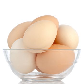 Brown eggs in transparent bowl isolated on white background.