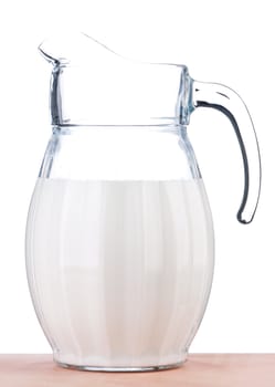 Jug of milk on wooden table on white background