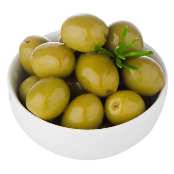 Green olives in a white ceramic bowl on white background.