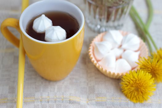 Herbal tea in glass cup and flowers on wooden table