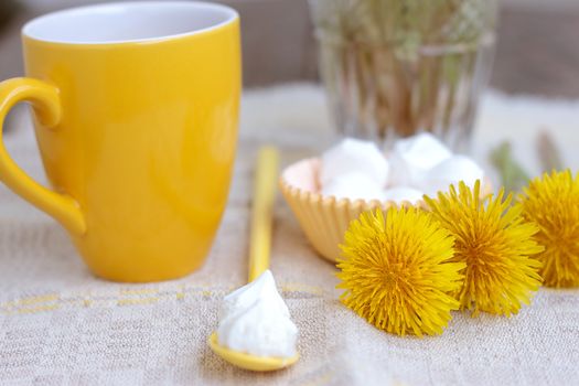 Herbal tea in glass cup and flowers on wooden table