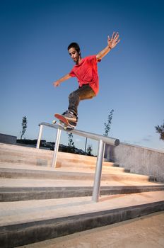 Skateboarder doing a FS Feeble on rail.