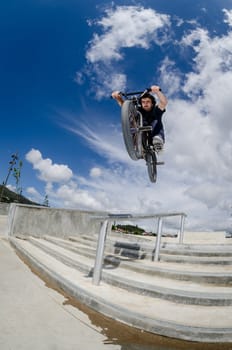 Bmx rider on a big air jump in a skate park.