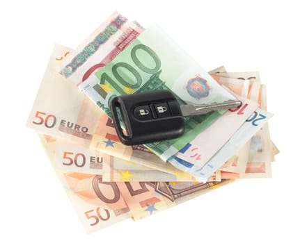 pile of euro banknotes with a car key isolated over with clipping path