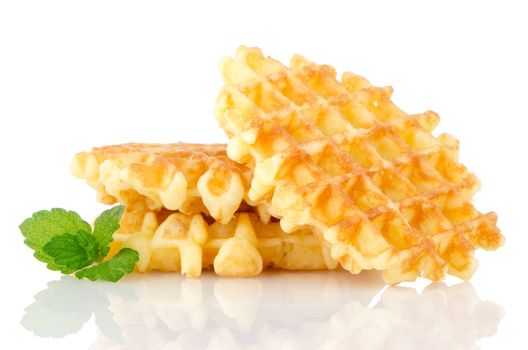 Pile of sweet waffles with green mint leaves isolated on white background.