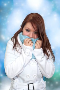 Portrait of a gorgeous winter woman wearing a blue scarf and white winter coat