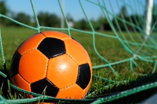 Goal. a soccer ball in a net. outdoors