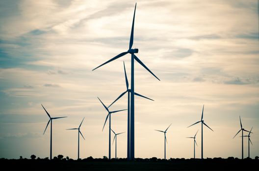 Backlit view of a group of mills for electric power generation