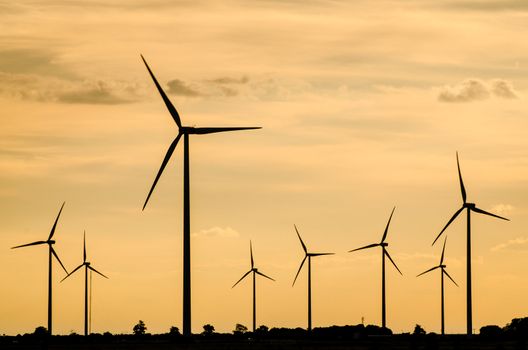 Backlit view of a group of mills for electric power generation