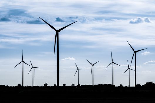 Backlit view of a group of mills for electric power generation