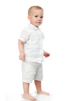 Full length portrait of a happy little boy standing isolated over white background