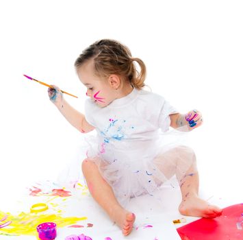 cute little girl with a brush and paints on a white